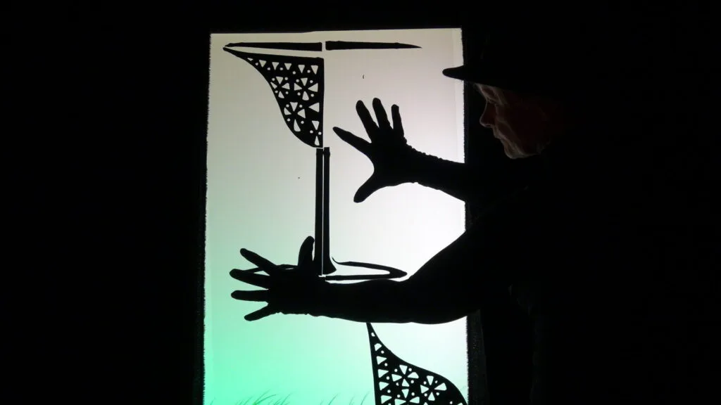 La demi-coupe en cristal , en ombres sont des morceaux noirs que la marionnettiste collent ou décollent sur l'écran lumineux vert fluo pour obtenir un autre objet. On voit très nettement ses mains gantées de noir en début de travail.